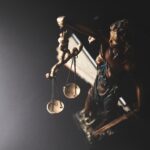 A close-up of a Lady Justice figurine holding a set of scales, representing legal principles.