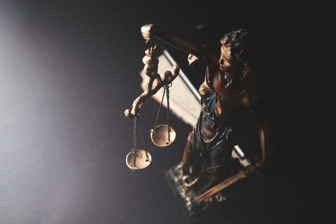 A close-up of a Lady Justice figurine holding a set of scales, representing legal principles.